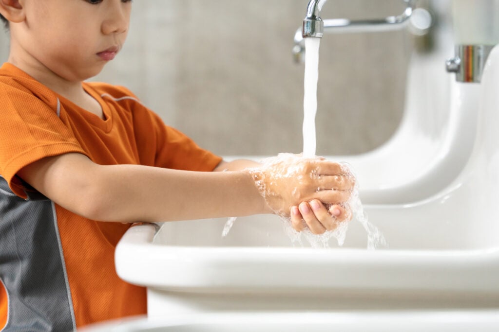 boy washing hands in the sink