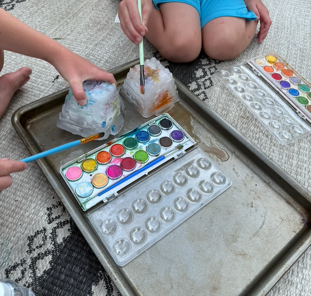 Preschoolers painting outside in the summer
